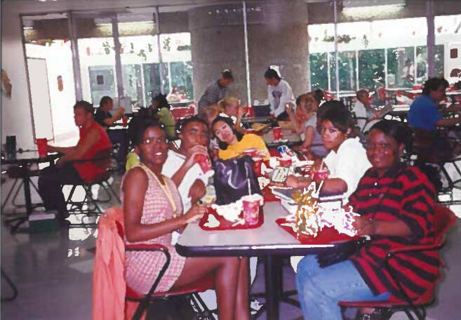 Students sitting at a lunch table eating food